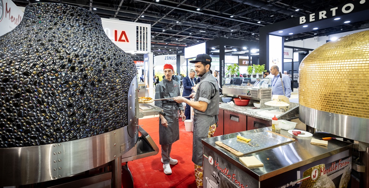Two tiled wood-fired pizza ovens with chefs working between them at GulfHost